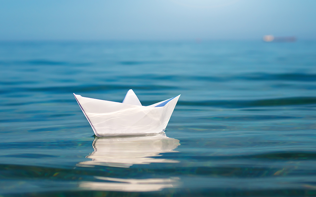 A little paper ship surfing on water representing the policy work and recommendations for future drinking water regulations.